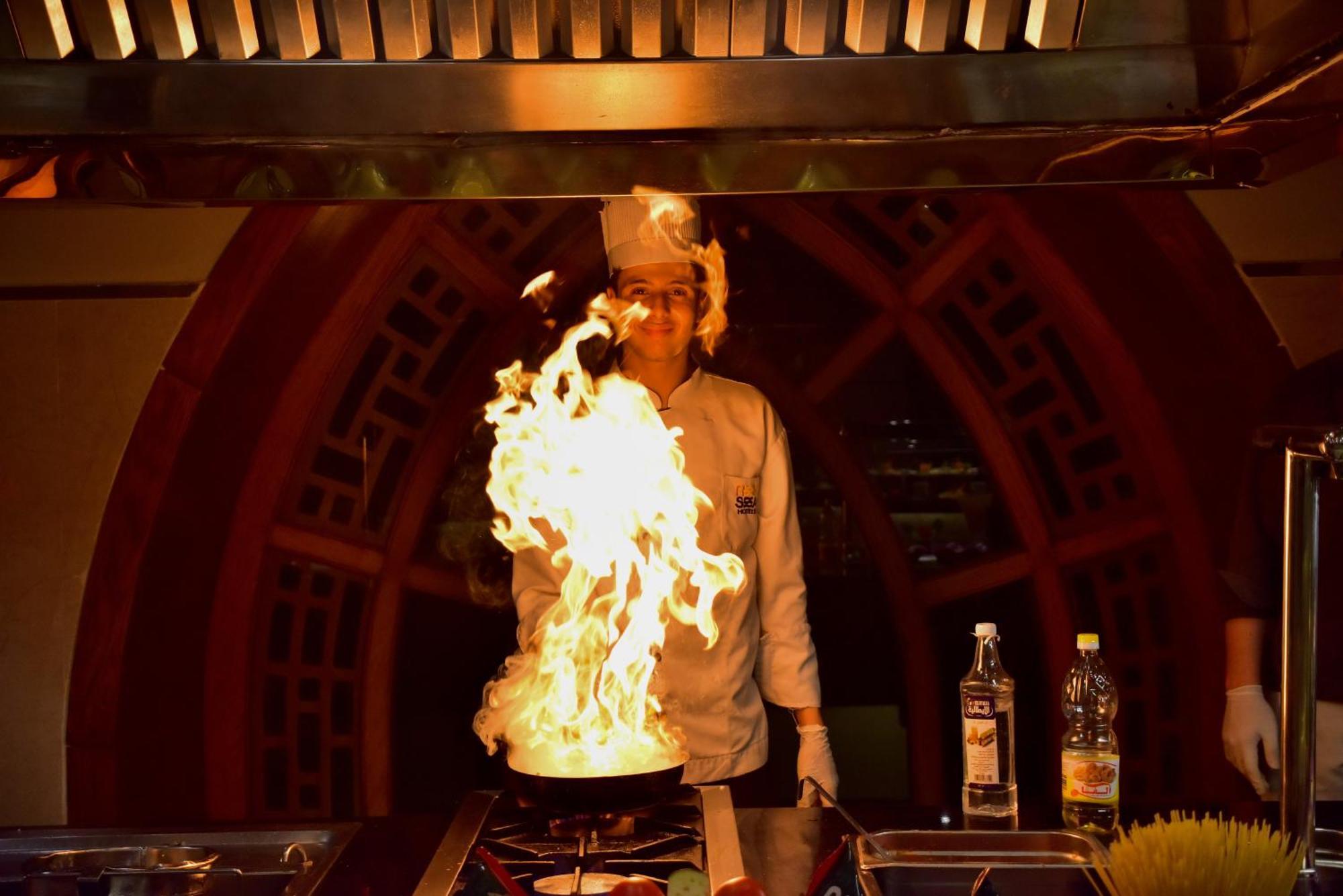 The Grand Hotel Sharm El Sheikh Экстерьер фото A chef cooking with a flaming wok